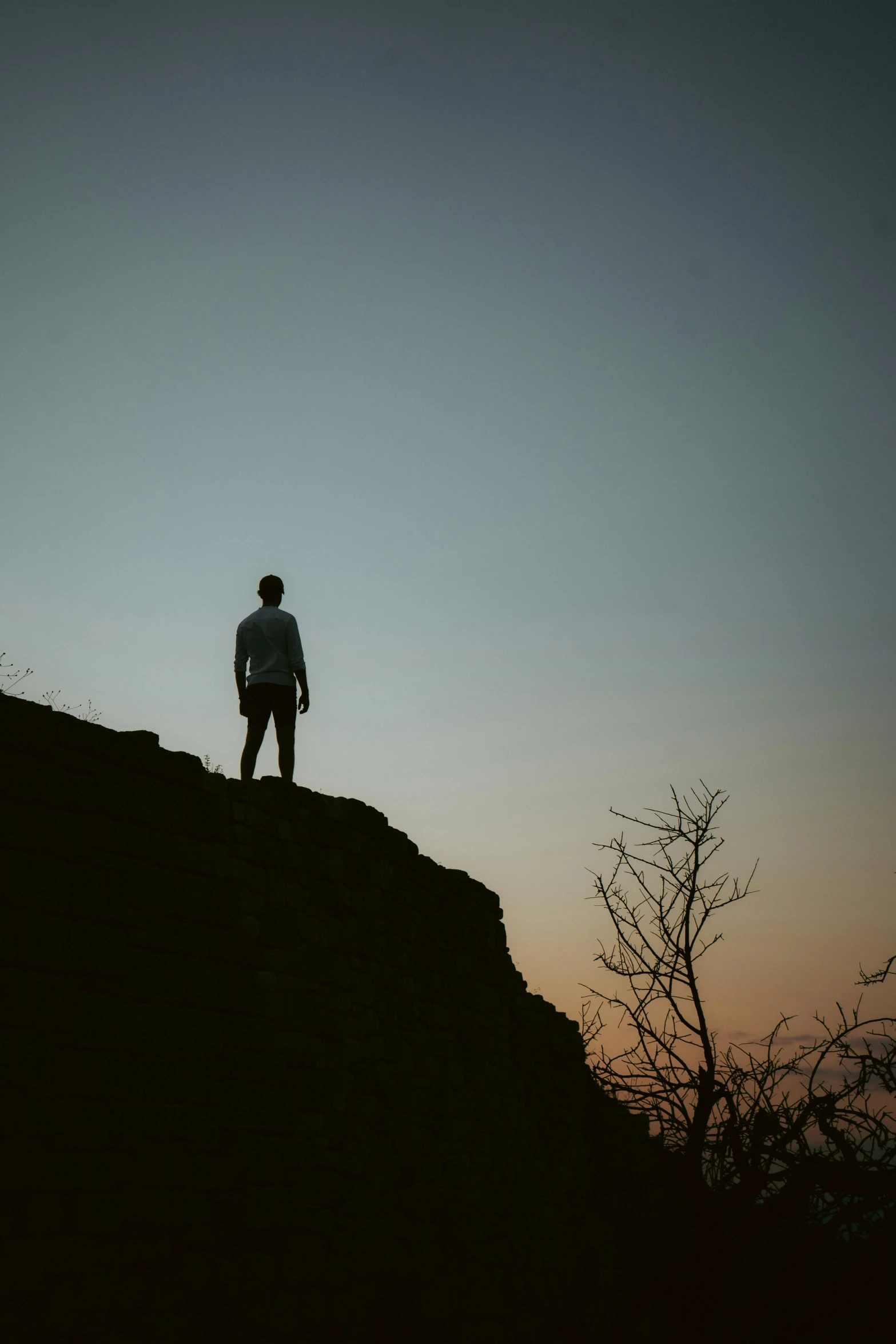 a man standing on top of a hill at sunset