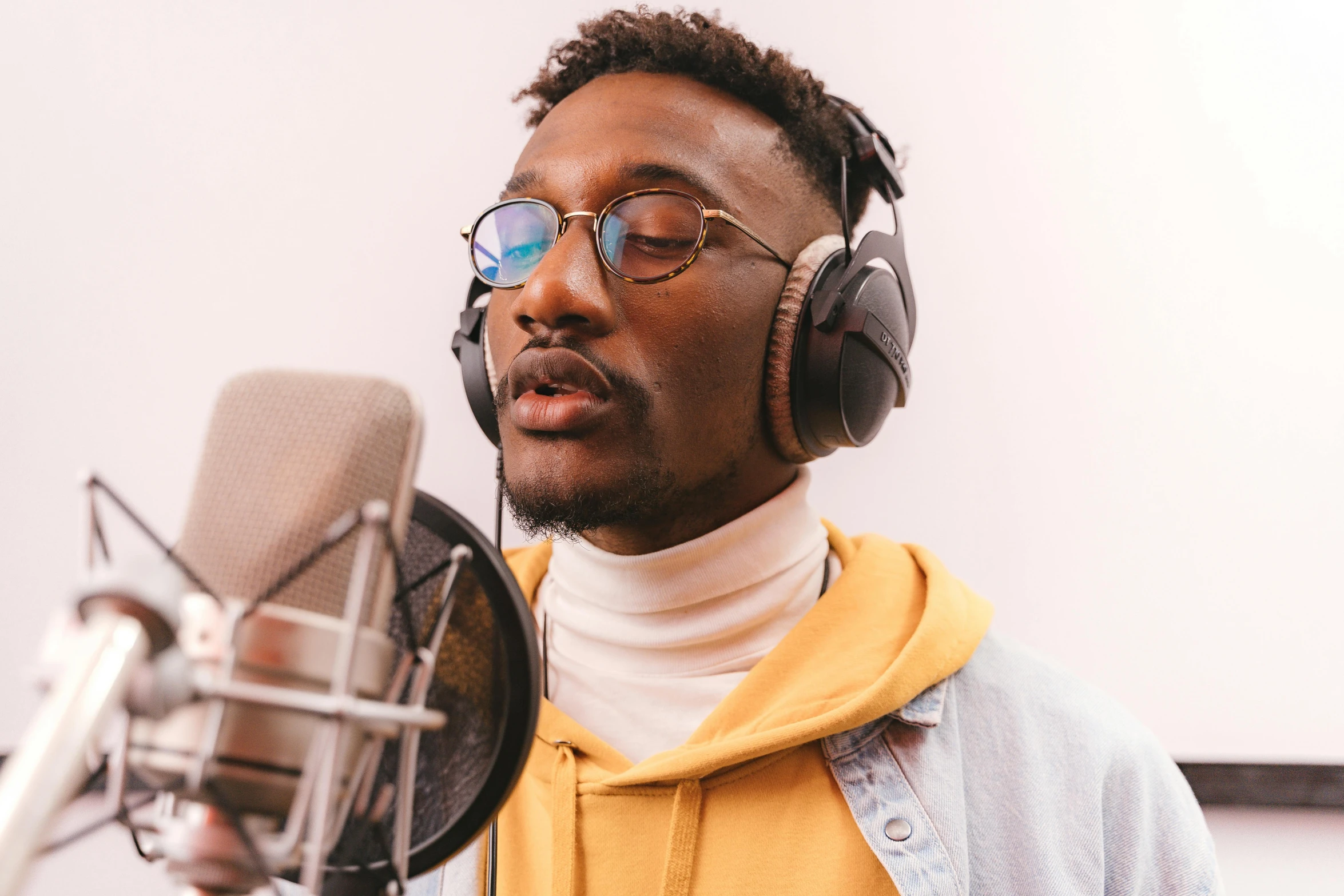 man wearing eyeglasses in recording studio setting