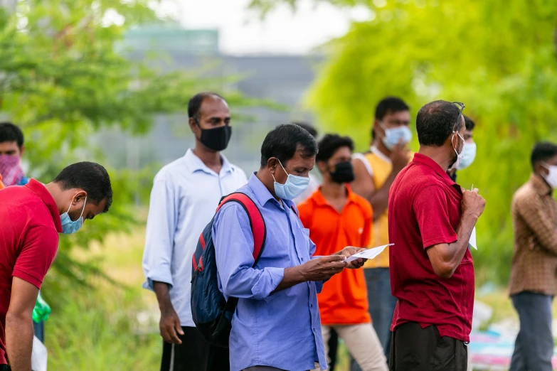 group of men in a park wearing masks