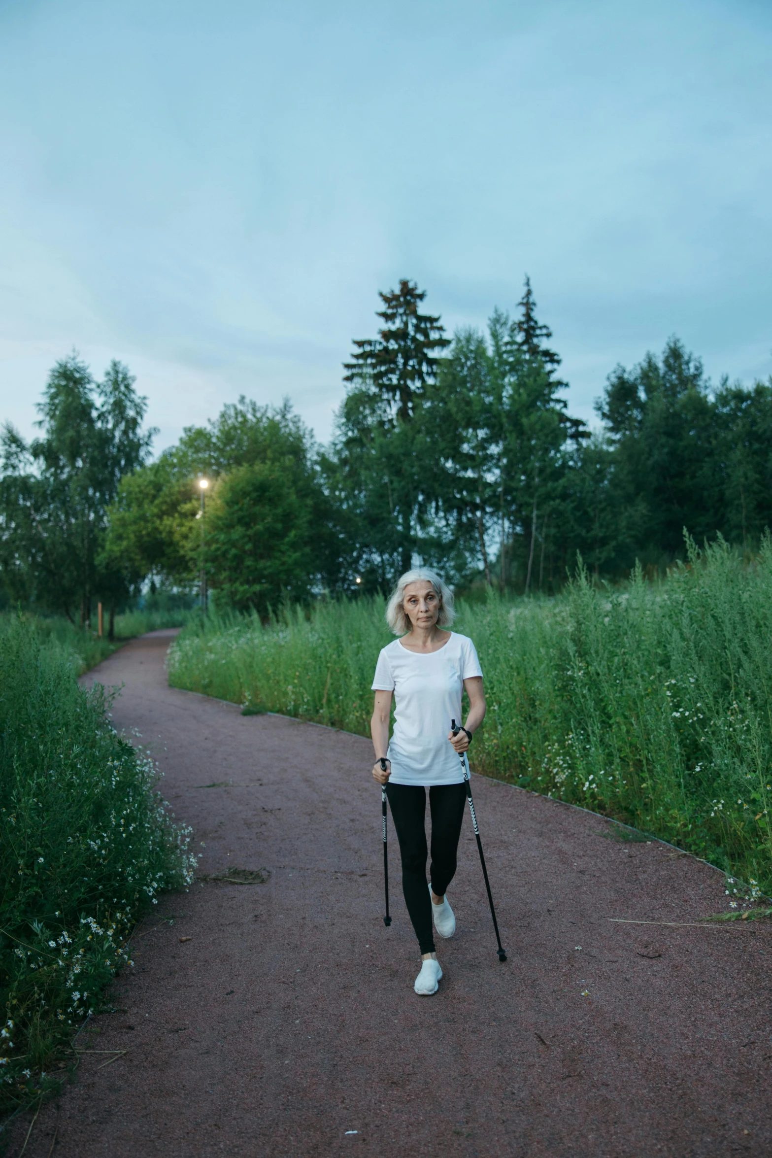 a lady walking down the road holding a cane