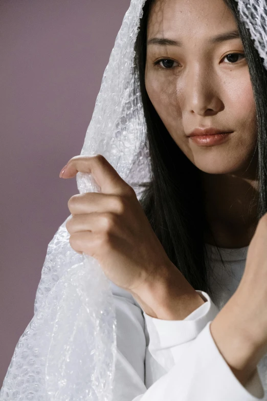 an asian woman is wearing a wedding veil