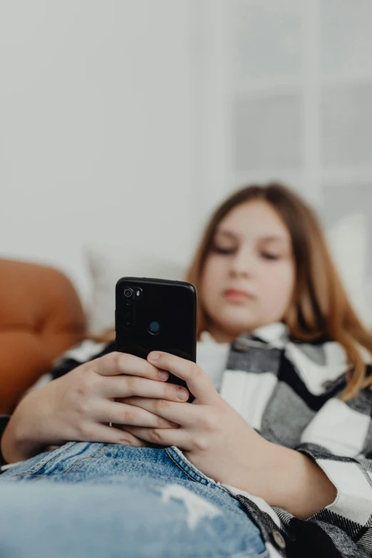 a woman laying on top of a bed using a phone