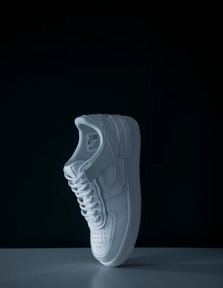 the shoe of an individual is seen on a dark background