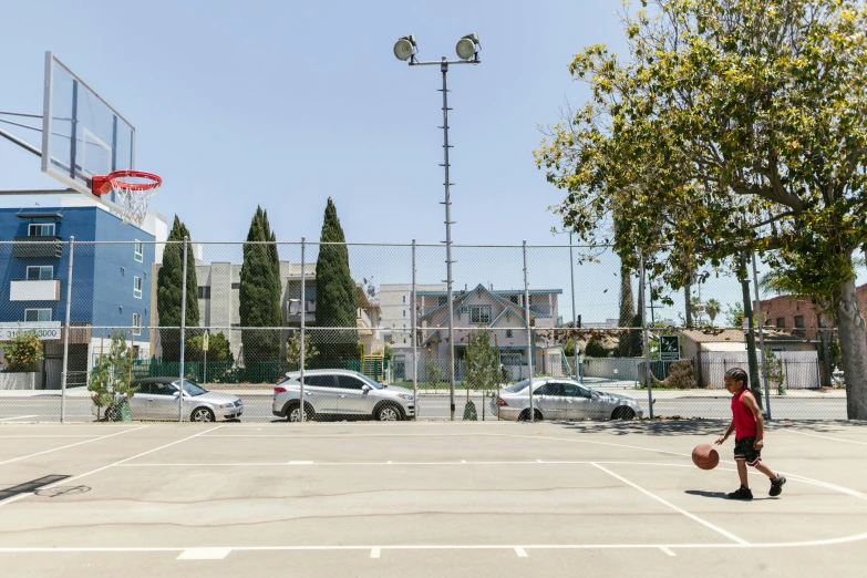 young children playing with basketball at outdoor basketball courts