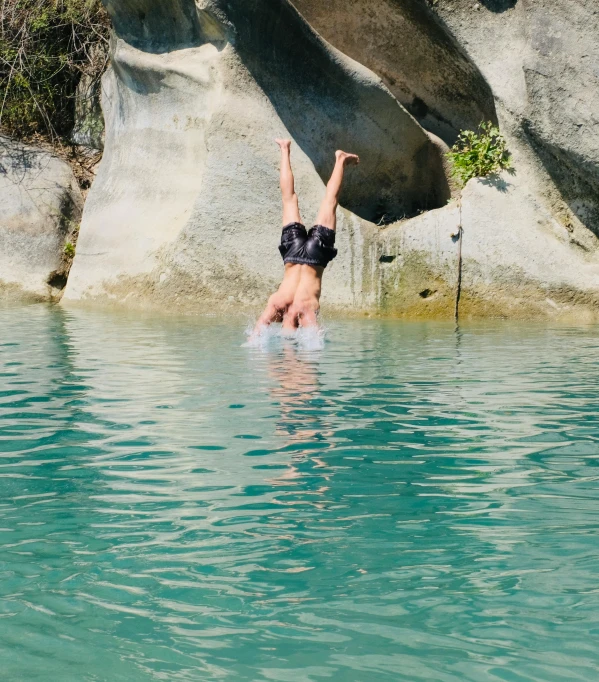 a woman diving into some water in a lake