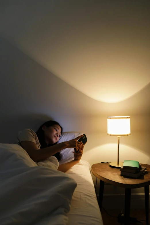 a woman in bed holding a beverage bottle