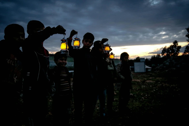 a group of people standing around each other holding lanterns