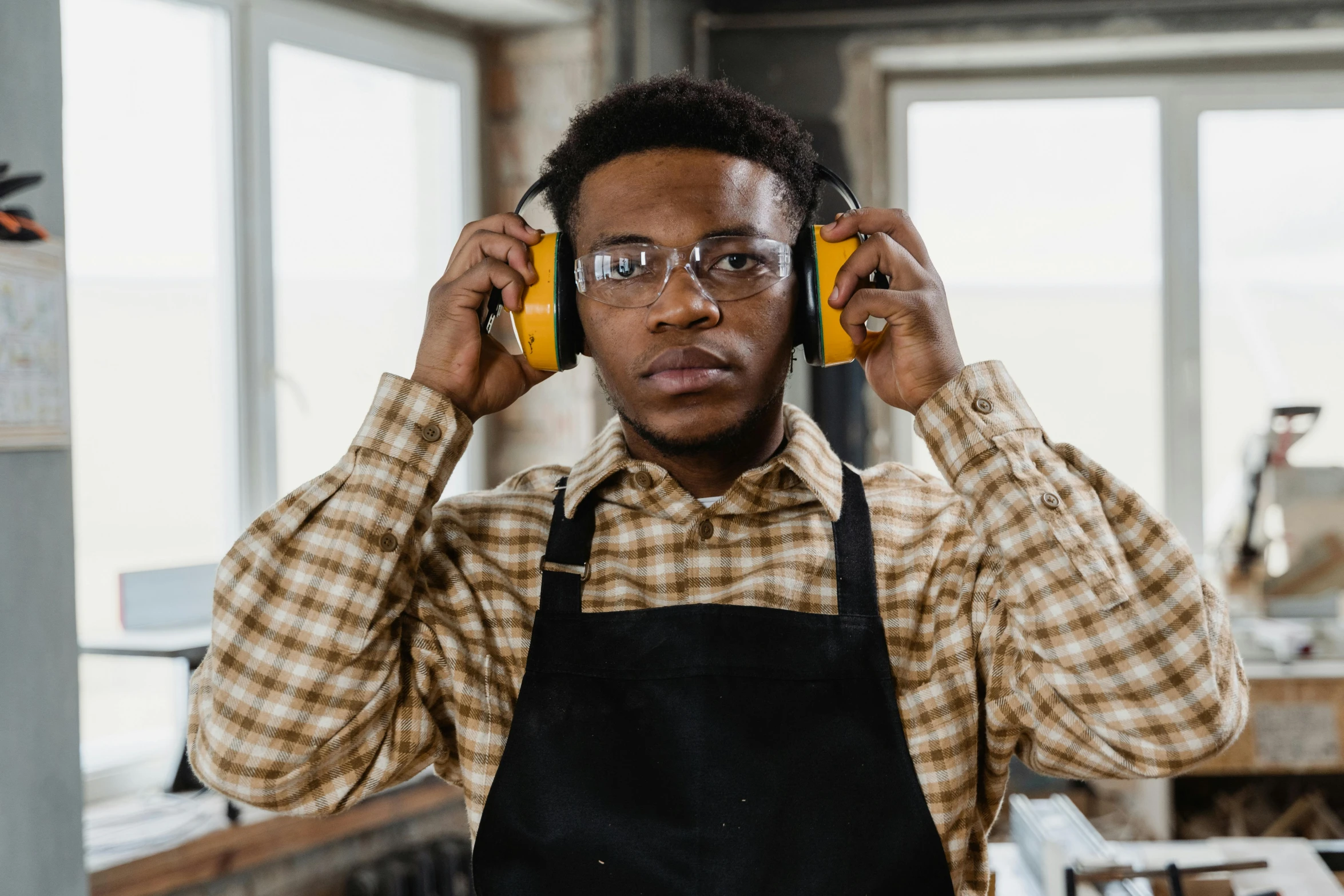 a man in an apron with headphones stands at his side