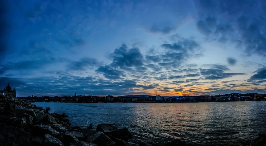 the sky is reflected in the water near the shore