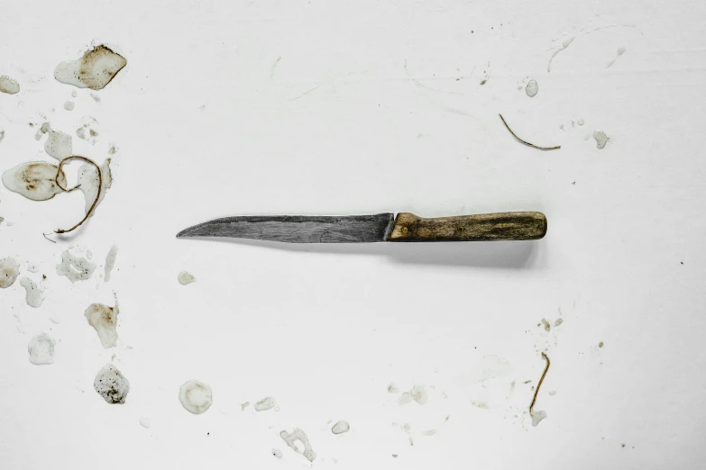 a dirty knife next to another object in the middle of some debris