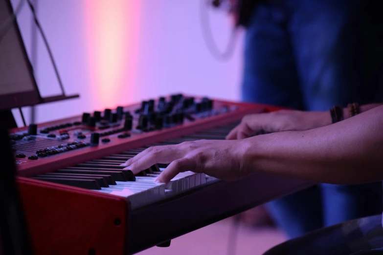 a man is playing the keyboard while his hands are resting on it