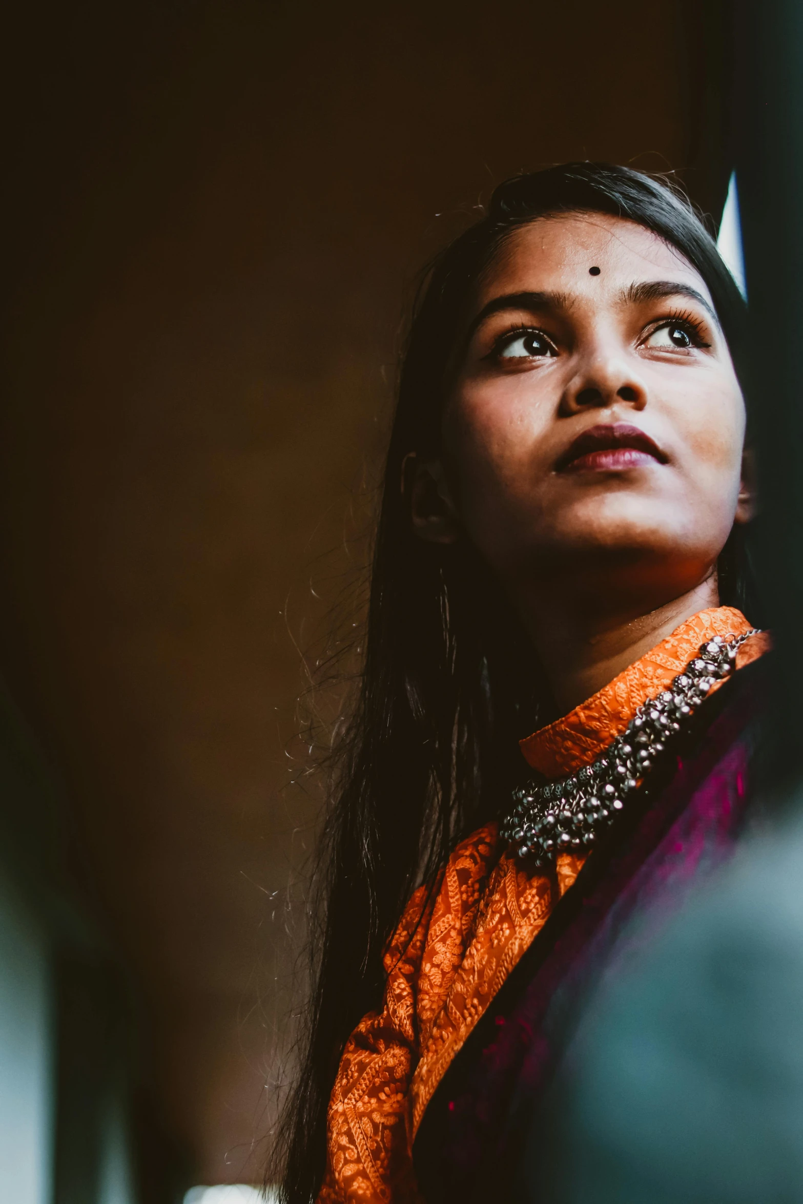 a girl looking up wearing orange and black