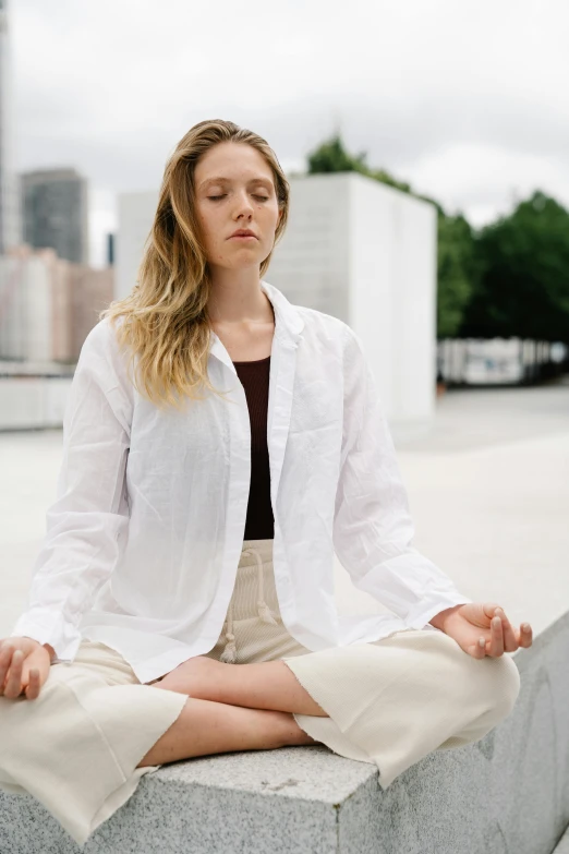 a young lady is meditating and enjoying her time