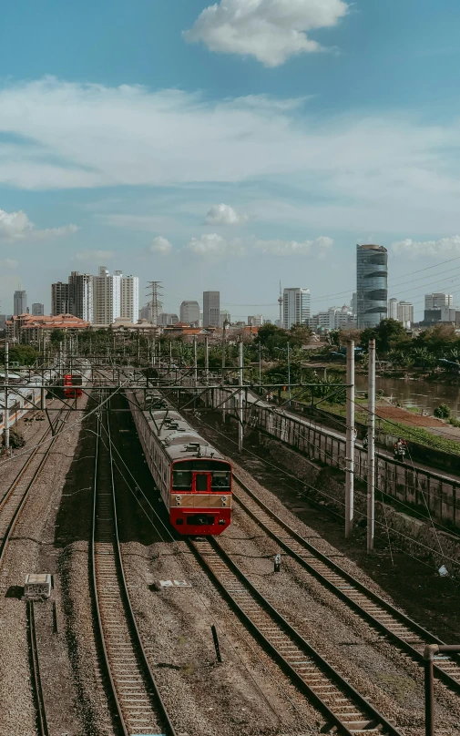 trains on tracks with skyscrs in the background