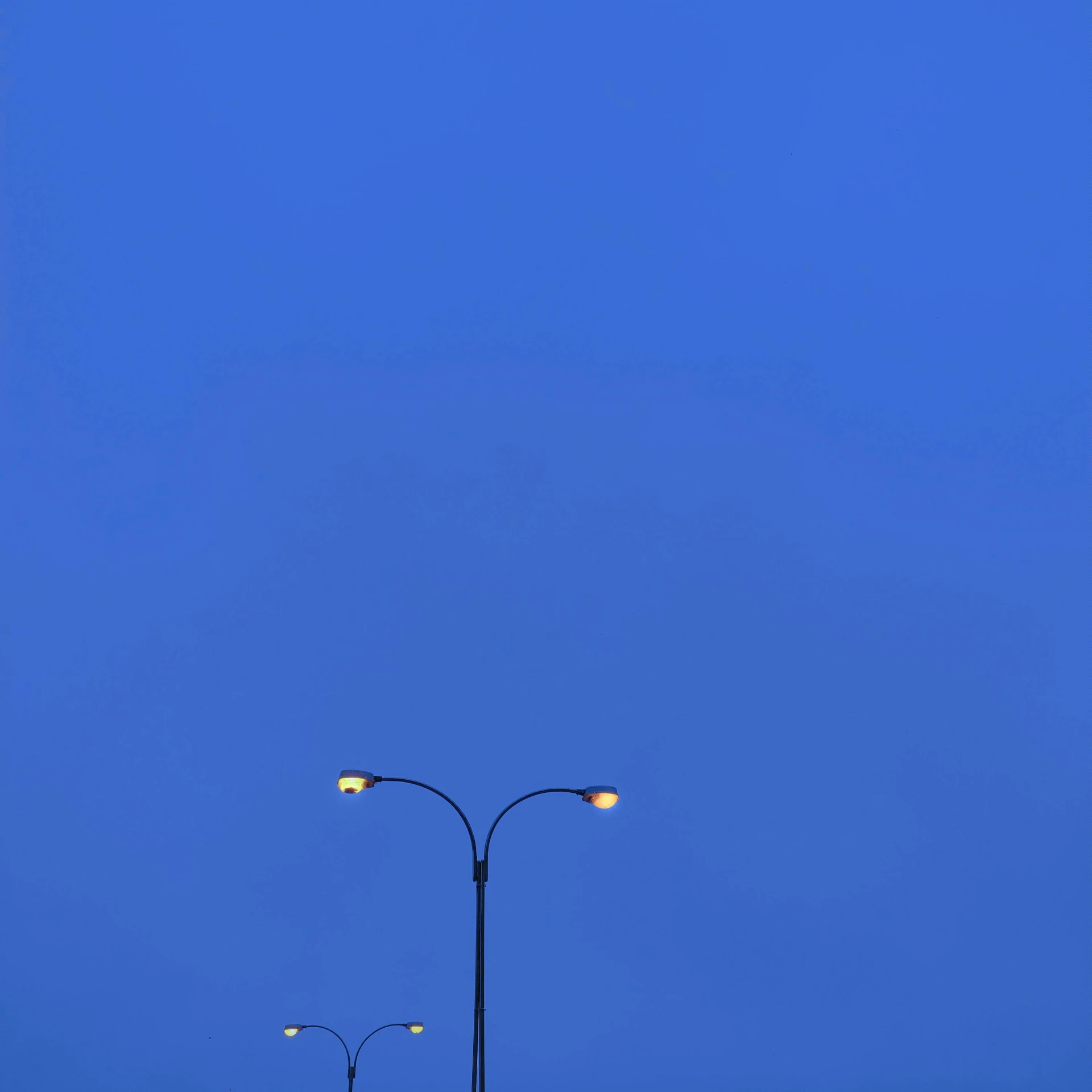 a lamp post sits on a street in the evening