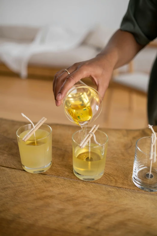 a person pouring some drinks from a pitcher