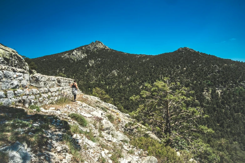 a lone hiker standing on a steep mountain