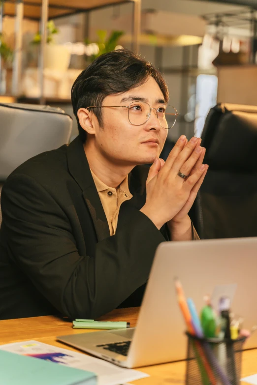 a man sitting at a desk while applauding a lap top