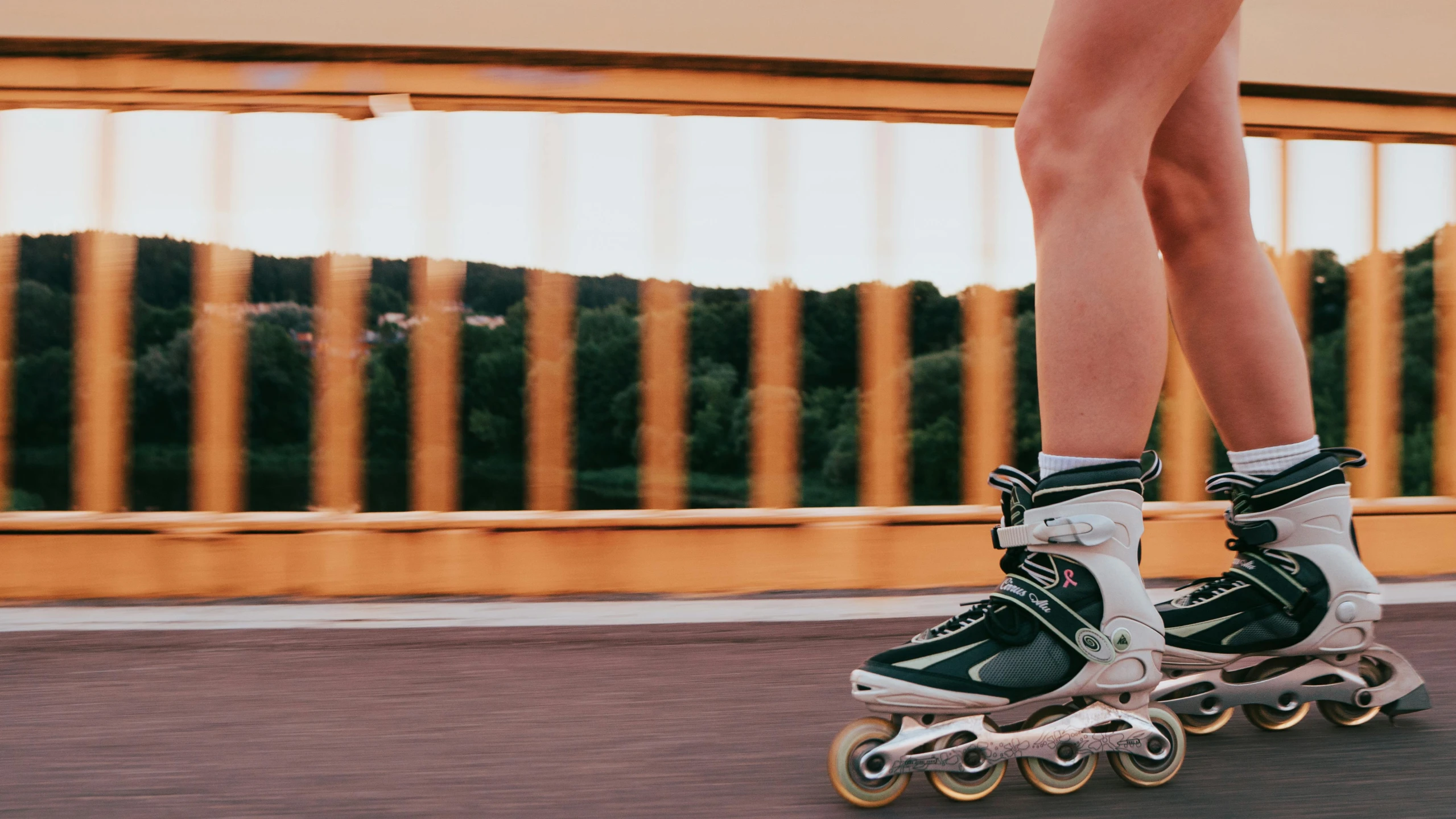 the feet of two roller blades are being hed along by one another