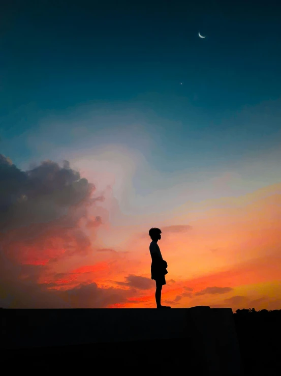 a person standing on top of a cliff with a cloudy sky in the background