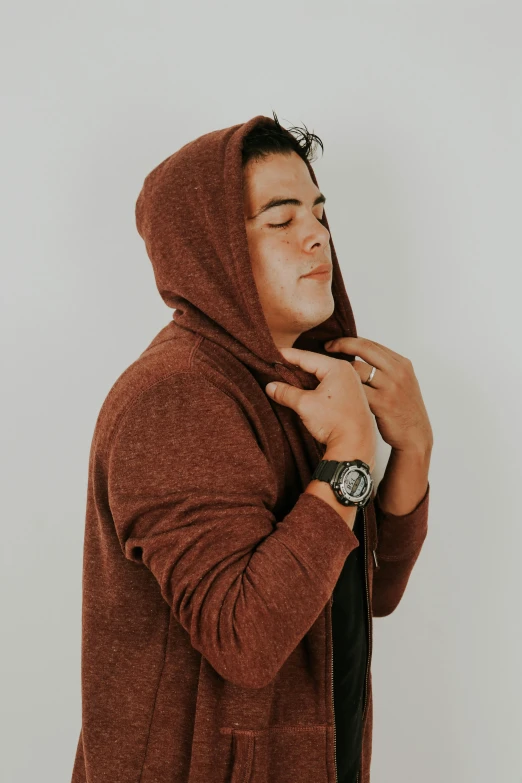 a young man wearing a hooded sweater with a watch