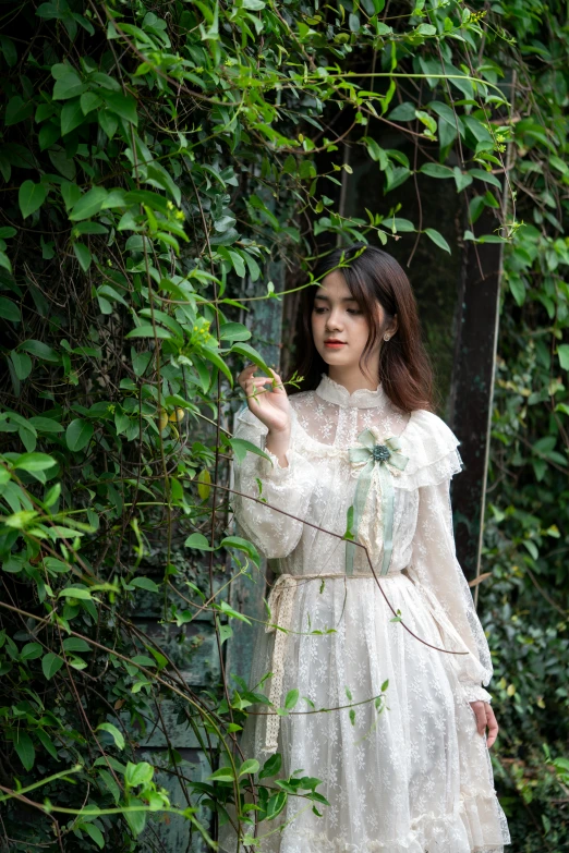 a woman standing in front of some ivy