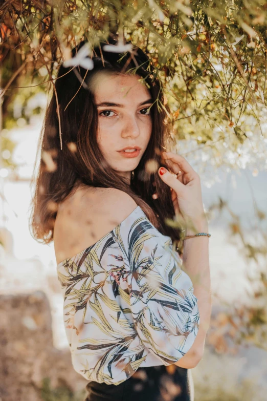 girl in short dress posing under a tree