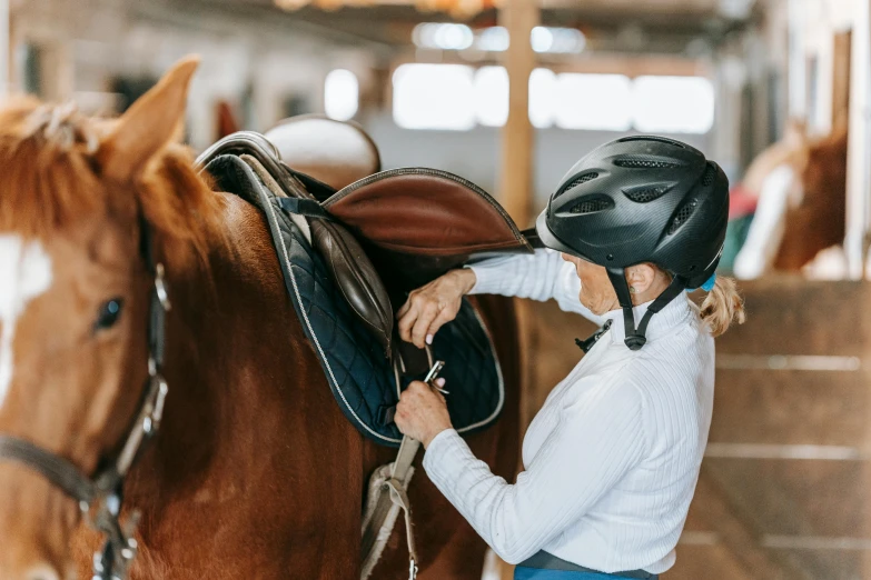 a woman standing next to a horse in an arena