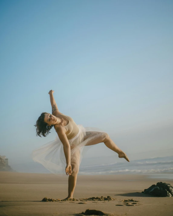 a woman on the beach holding her legs high