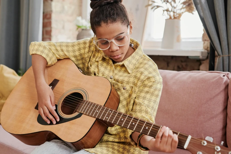 a woman sitting on a couch with a guitar