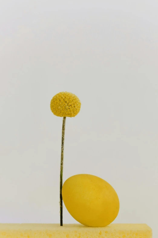 a yellow sculpture with a flower in the middle