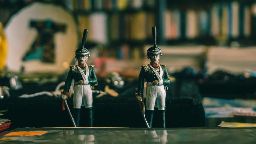 toy soldiers wearing uniforms are shown in front of a bookcase