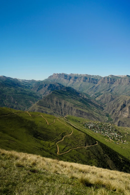 looking down on a mountain with a town in the distance