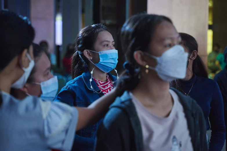 several people in masks standing on a street