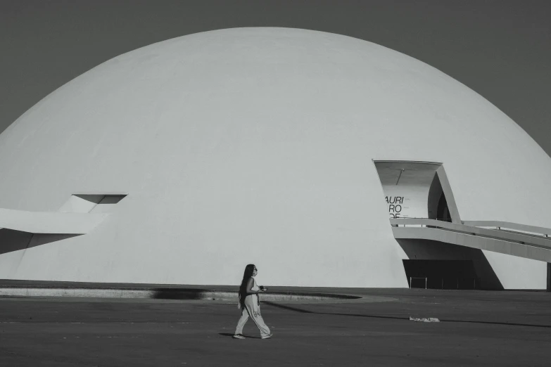 a man walks down the street in front of a building