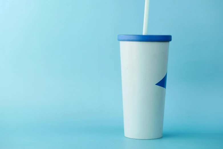 the cup is white and blue with a toothbrush in it