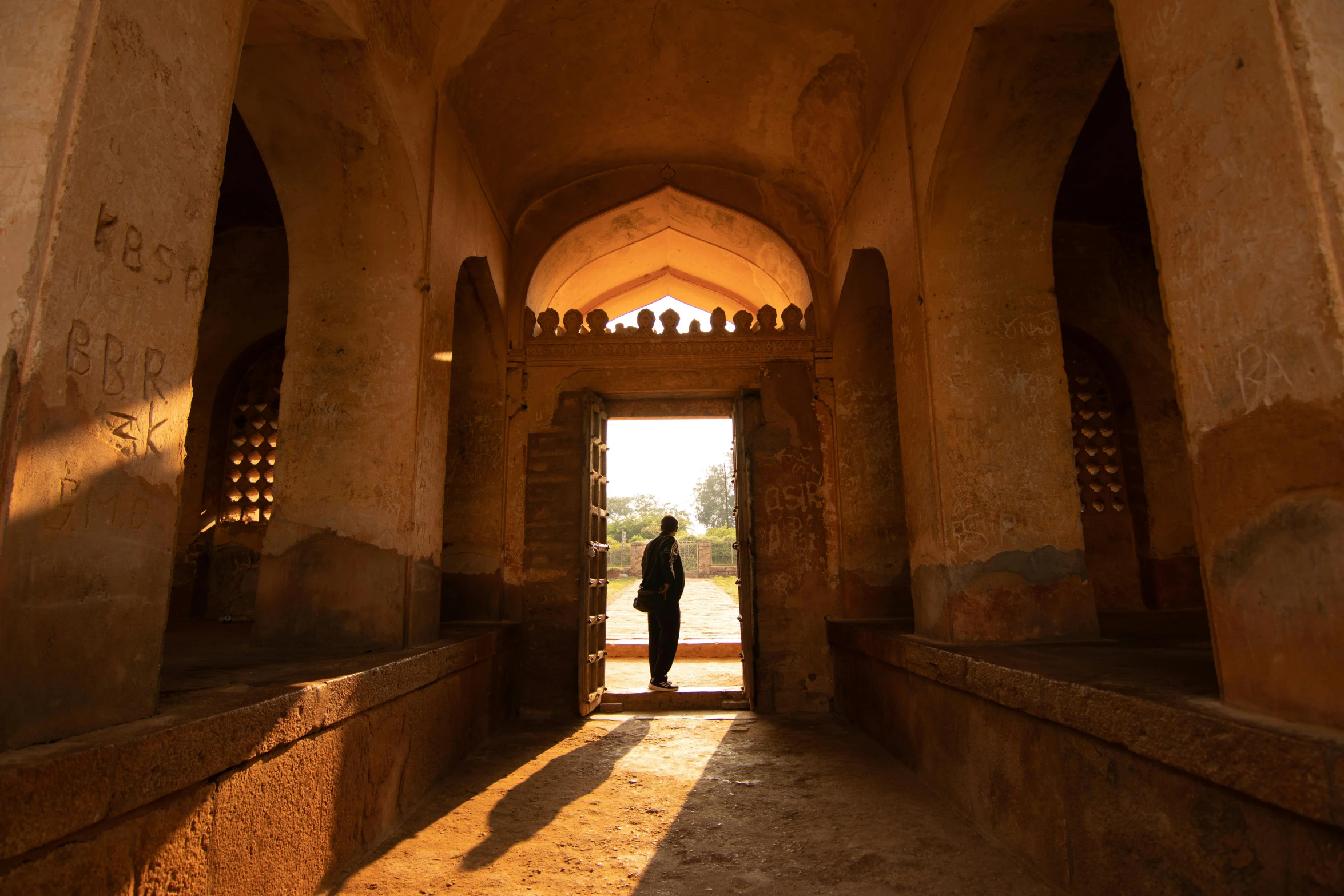 a person in front of an archway in a stone building