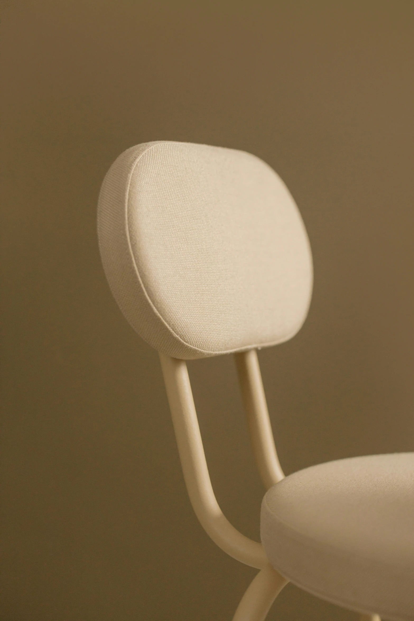 a white chair sitting against a wall in a room