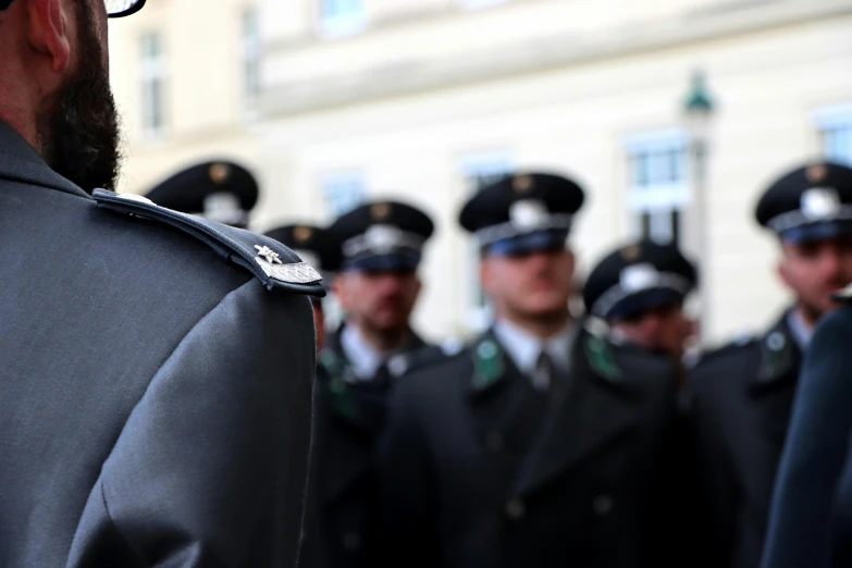 men in uniforms stand together outside of a building