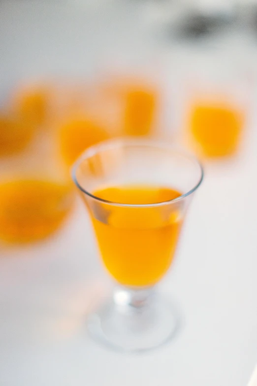 some oranges are in a glass on a table