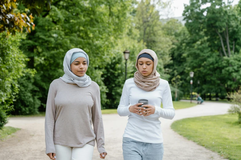 two women walking together holding cell phones