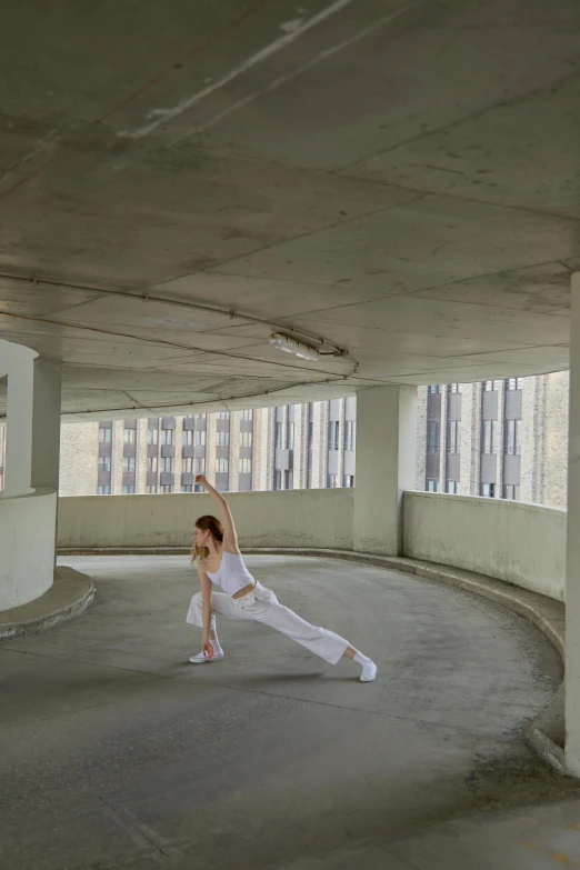 a woman dressed in white practicing a dance move