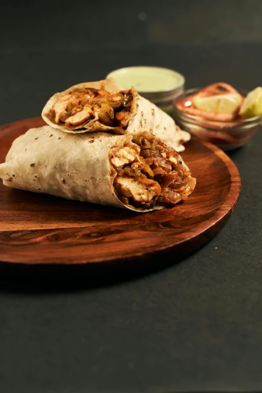 a burrito that is sitting on a wooden platter