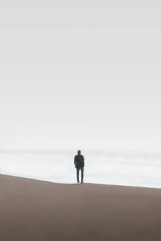 a person standing in the sand with a surf board