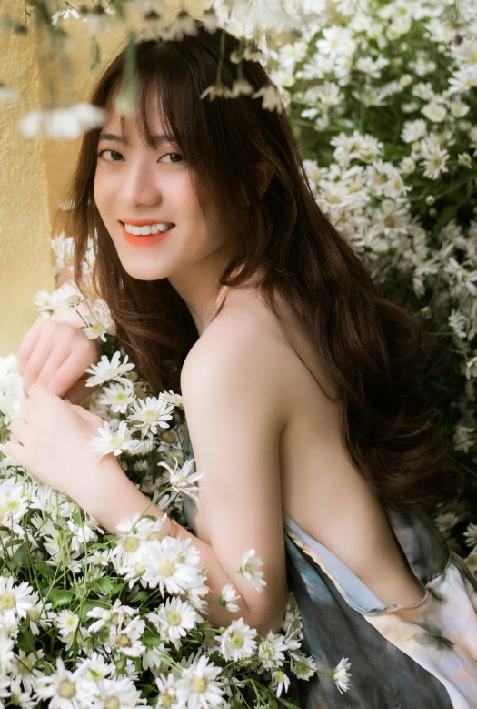 a woman sits under flowers in the grass