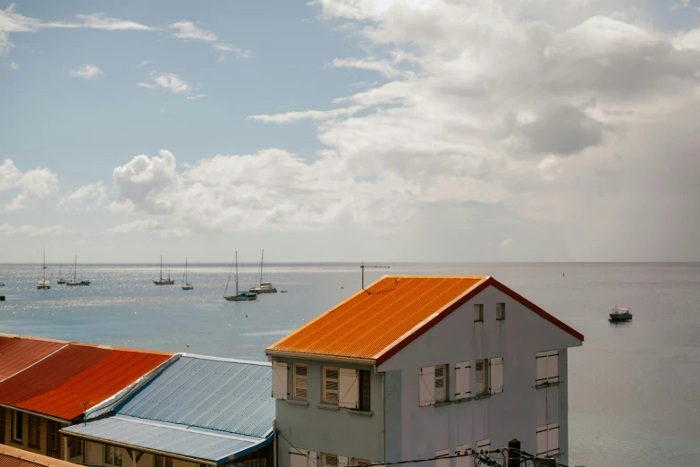 a home with orange roofs sits near the ocean