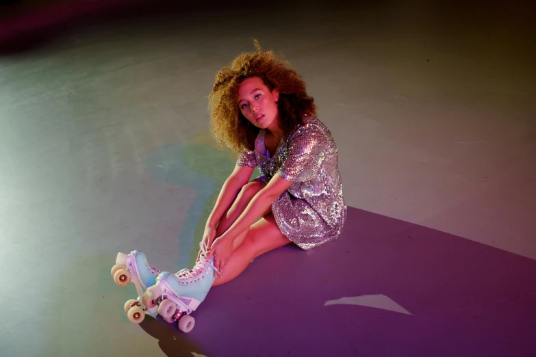 woman riding a skateboard while sitting on a purple surface