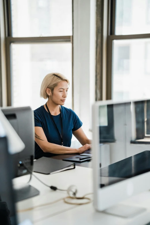 a woman sitting in front of a computer monitor