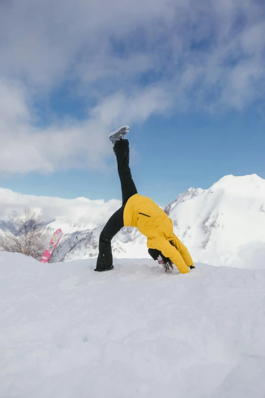 a man doing a hand stand on top of a snow covered ground