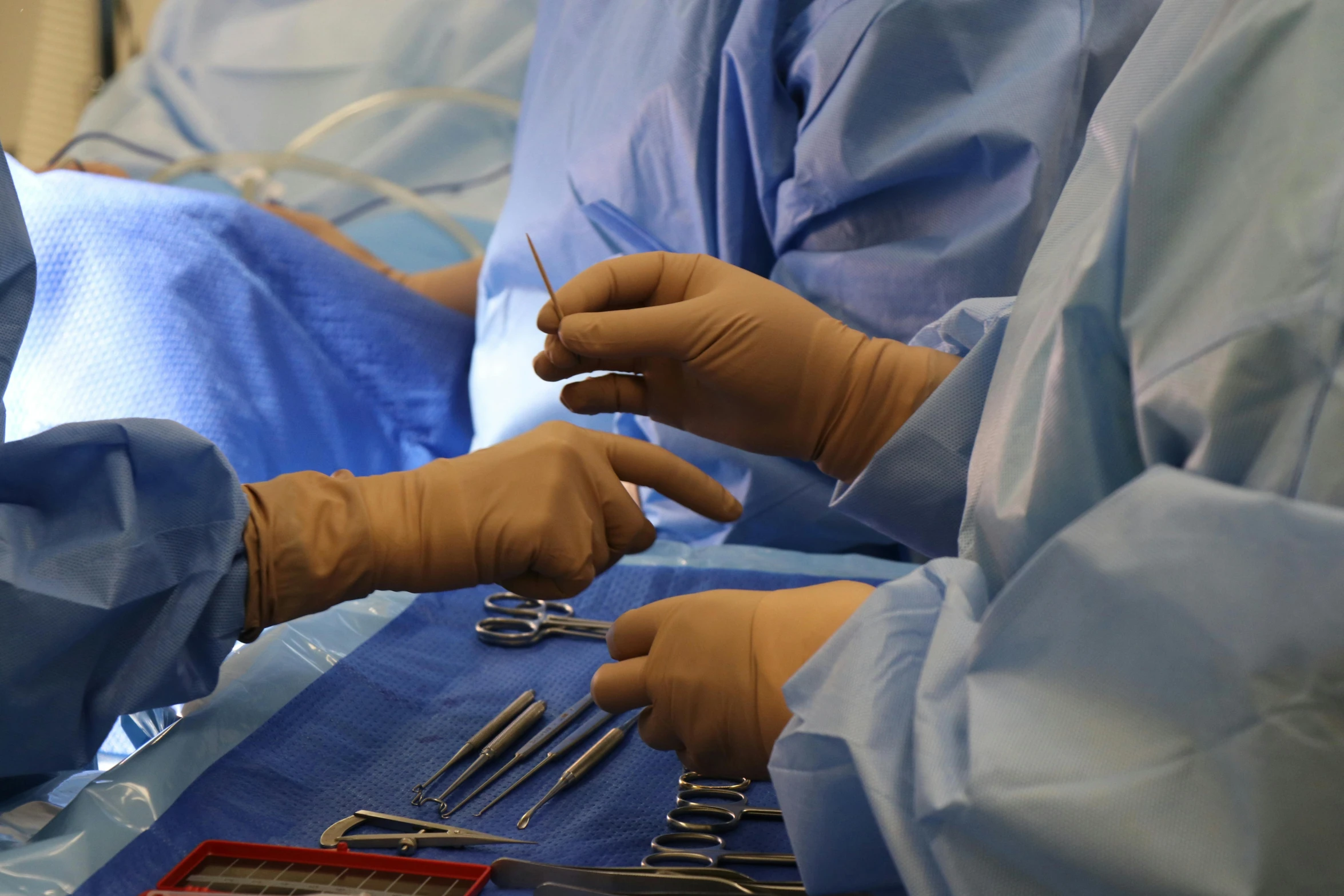 medical workers in sterile garb operating dental instruments